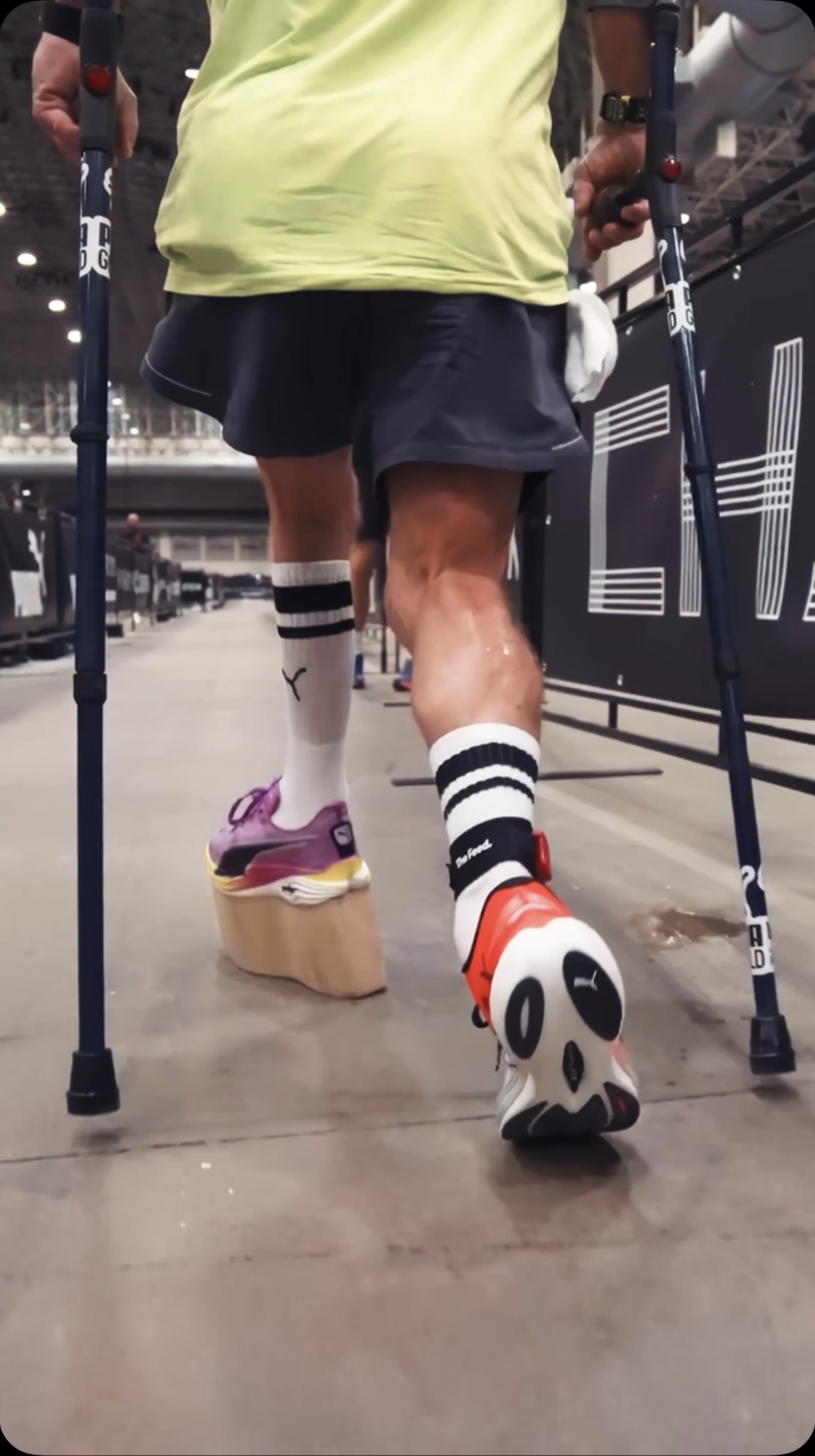 Close-up of David's crutches and raised shoe during a HYROX race